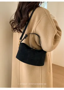 Détail du sac lune en daim noir minimaliste avec ferrures dorées et bandoulière en cuir