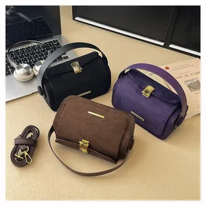 Dettaglio di borse vintage in pelle scamosciata opaca in nero, viola e marrone con fibbie oro