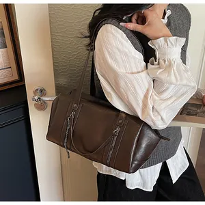 Vue détaillée du sac à bandoulière vintage marron foncé avec chaîne et détails zippés