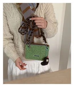 Détail du sac bandoulière pelucheux vert moutarde porté par un mannequin femme