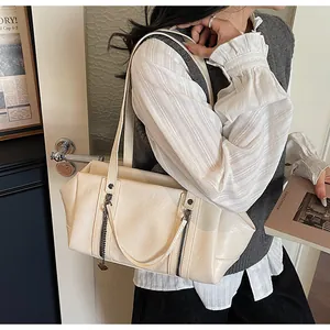 Détail d'un sac cabas en cuir PU blanc crème avec double fermeture éclair et chaîne