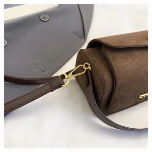 Dettaglio della borsa a tracolla in camoscio testa di moro con finiture in oro lucido