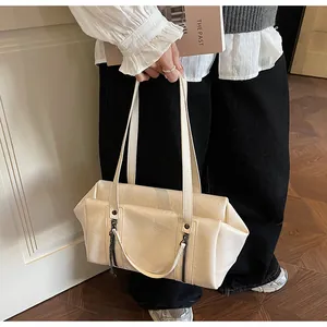 Détail du sac à bandoulière crème en similicuir avec fermeture éclair et chaîne