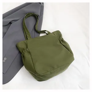 Dettaglio della borsa tote in nylon verde militare con pieghe e texture morbida