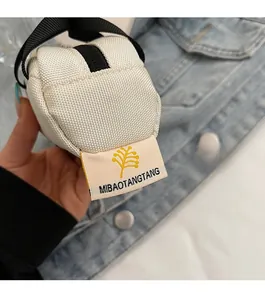 Detailed view of a mini canvas bag featuring a black zipper and hand strap
