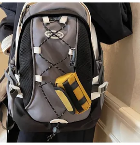 Close-up of yellow and black mini accessory pouch attached to a grey backpack