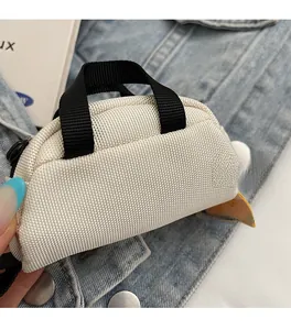 Detailed shot of an off-white mini canvas handbag with a black handle and side zipper