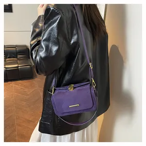 Dettaglio della borsa a tracolla in pelle scamosciata viola con chiusura a ventaglio dorata