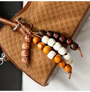 Close-up of brown woven texture handbag featuring colorful beads and silver hardware