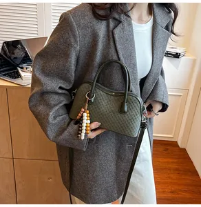 Detail of olive green woven leather handbag with colorful beaded tassel charm