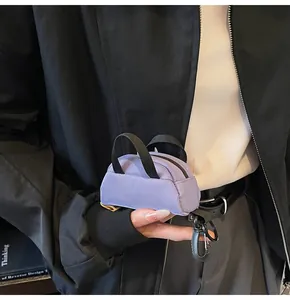 Close-up of a purple mini canvas bag keychain with a sturdy black carabiner and zipper