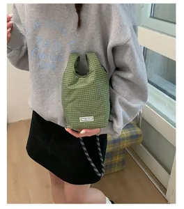 Detailansicht der grün-weiß karierten Stofftasche mit gewebtem Seilgriff und Logo-Aufnäher