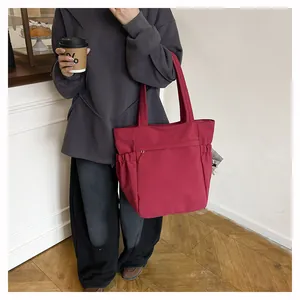 Vista dettagliata della borsa tote rosso rosa con nylon impermeabile e tasche laterali