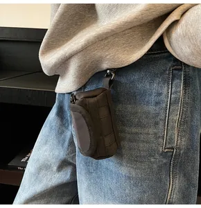 Detail of black tactical nylon mini pouch with MOLLE webbing and metal spring clip