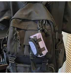 Close-up of a purple mini canvas pouch with a carabiner attached to a black backpack