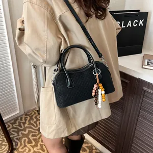 Women's black woven handbag with wooden bead charm and long shoulder strap