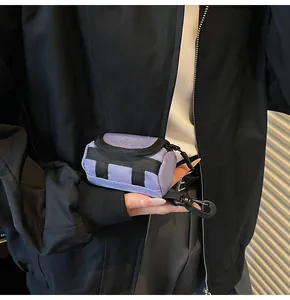 Handheld mini lavender canvas cylinder bag with black strap and carabiner hook detail