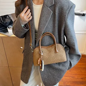 Brown micro-checkered leather handbag with vintage bead charm and shoulder strap