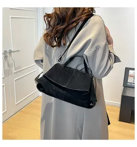 Scatto lifestyle della borsa a tracolla in pelle scamosciata nera con patta