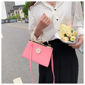 Gros plan sur un sac à main rose rayé avec poignée en perles et camée rétro