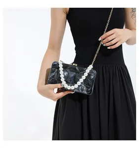 Detailed view of acrylic marble textured crossbody bag with pearl handle and metal chain