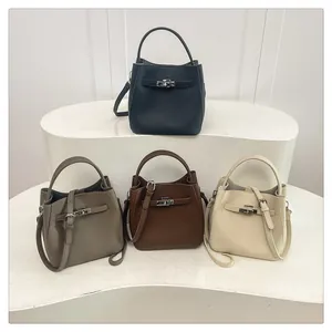 Close-up of litchi grain leather bucket bags with signature metal turn-lock detail