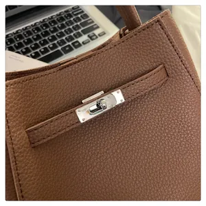 Macro shot of brown pebble leather texture and silver metal twist-lock on bucket bag