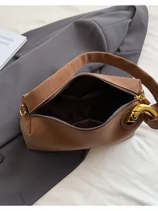 Dettaglio della borsa tote marrone con grande fibbia a catena dorata e zip interna
