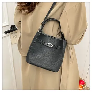 Detail of black lychee grain leather bucket bag with silver buckle and shoulder strap