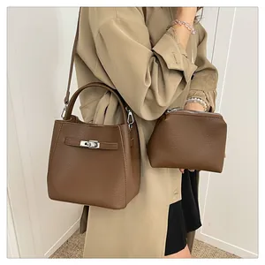 Detailed view of brown lychee grain leather bucket bag with silver buckle and crossbody strap