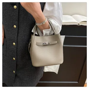 Detailed close-up of beige lychee grain bucket bag with silver metal twist lock