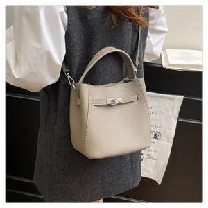 Detail of lychee pattern bucket bag with silver turn-lock and detachable strap in a cafe
