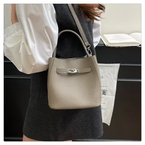Detail shot of grey bucket bag showing litchi leather texture and silver swivel lock buckle