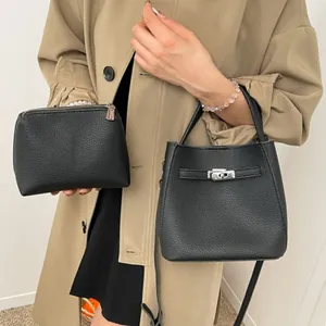 Chic black litchi pattern bucket bag and pouch set on a beige trench coat background