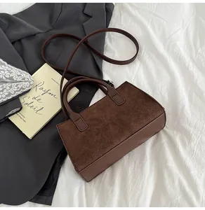 Dettaglio della borsa vintage color caffè con cuciture a griglia e trama in pelle