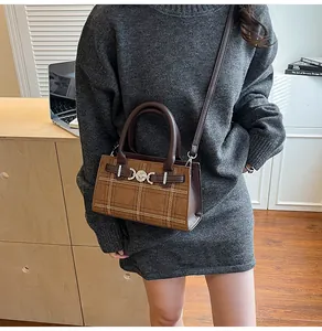 Dettaglio della borsa tote marrone vintage a scacchi con fibbia metallica argento