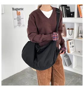 Vue détaillée du grand sac bandoulière en nylon noir avec cordon de serrage et texture plissée
