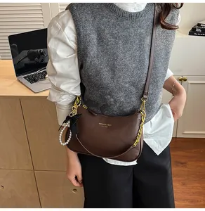 Borsa a tracolla marrone scuro con texture litchi, ciondolo a fiocco e doppia tracolla