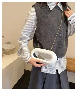 Sac bandoulière capsule blanc moderne avec détail miroir et chaîne dorée sur un mannequin
