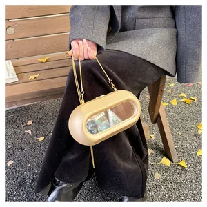 Détail du sac capsule or champagne avec insert miroir et fine bandoulière chaîne