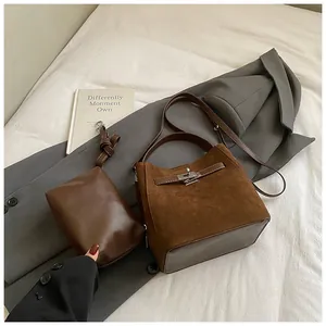 Gros plan sur l'ensemble sac seau en daim marron avec boucle rotative en métal
