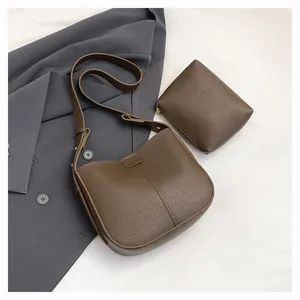Détail d'un sac à main en cuir marron foncé avec porte-monnaie carré zippé assorti