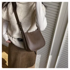 Vue détaillée du sac seau en cuir marron grainé avec une bandoulière réglable