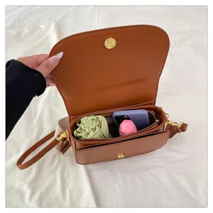 Capacité interne du sac selle marron montrant l'espace pour téléphone et parapluie