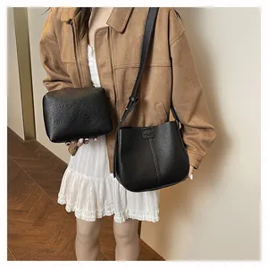 Détail du sac seau noir grainé avec sa pochette zippée assortie pour femme