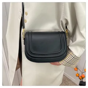 Sacoche selle classique en cuir noir avec large bandoulière et boucle en métal doré