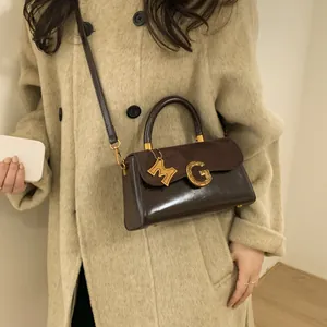 Brown frosted leather handbag with vintage gold G-logo and shoulder strap for women