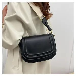 Détail du sac besace noir avec coutures contrastées et large bandoulière en tissu