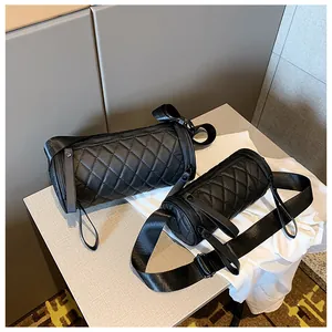 Detail of black quilted cylinder bags with adjustable wide straps and zip closure