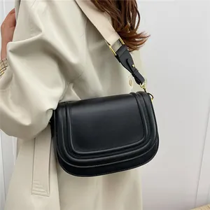 Sacoche classique en cuir noir pour femme avec une large bandoulière en tissu et boucles d'or